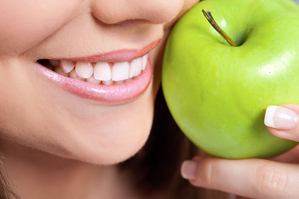 Smiling Woman Holding an Apple